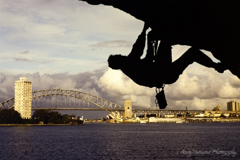 A climbers scales the overhang on Balls head in Sydney Harbour.