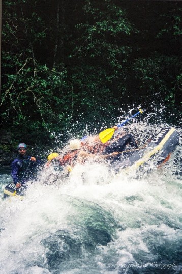 A raft guide looks cool and calm regotiating a rapid as the rest of his crew loose their grip.