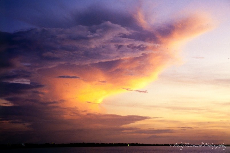 The last of the suns rays hit a building storm cloud over the city of Darwin.