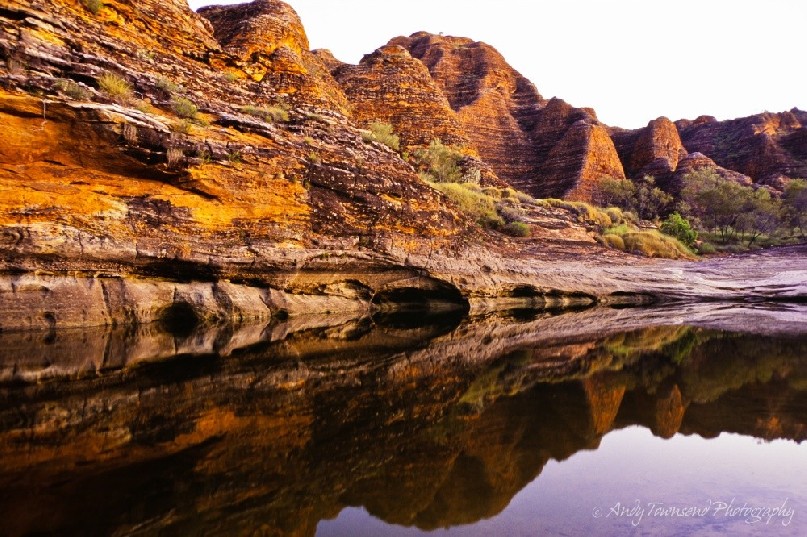 Sandstone domes reflect into a rare summer pool of water.