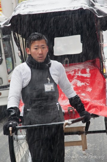 A rickshaw driver caught in a rare Tokyo snowstorm.
