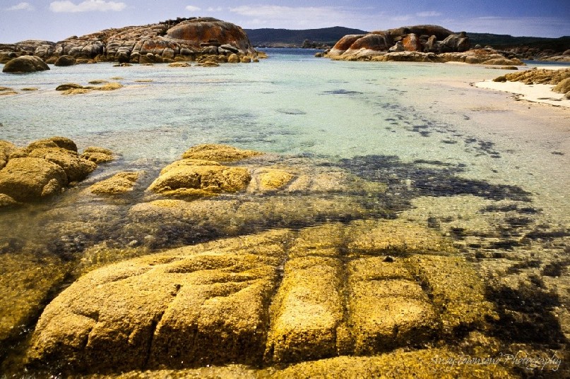 White sand and turquoise waters surround granite outcrops on Flinders Island, Tasmania, Australia.