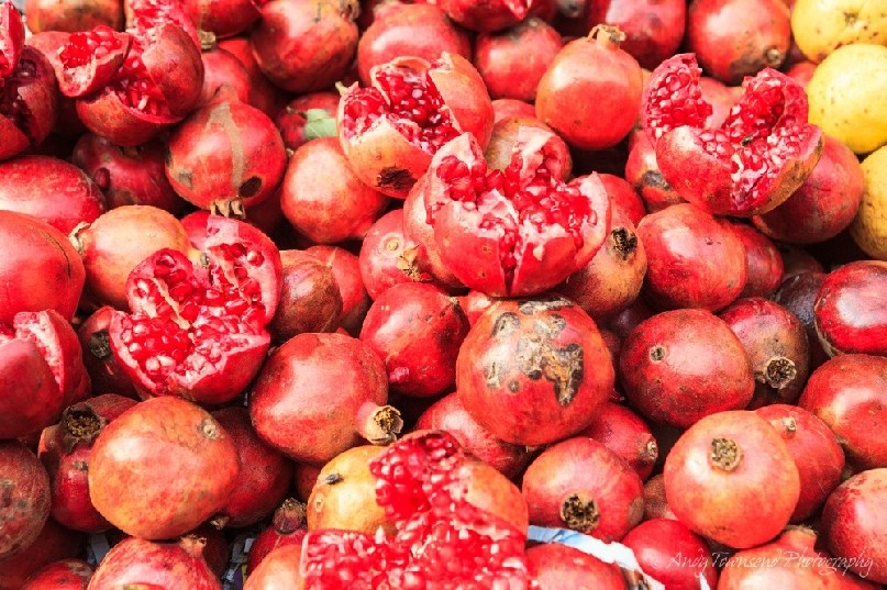 Close up of fresh pomegranates at a wholesale vegetable market.