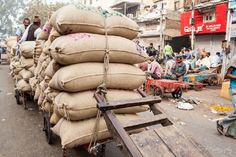 Large sacks of spice sit on wooden trolleys ready for distribution.