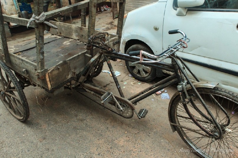 An old bike with an attached wooden cart.