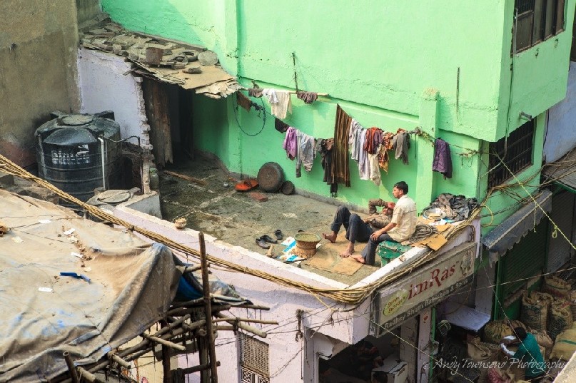 Two men relax on the roof enjoying a chat above the wholesale spice market.