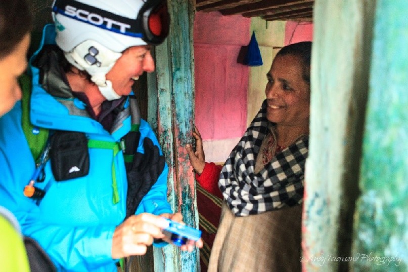 A female skier enjoys a moment showing a local Drung village woman a photograph she's just taken.