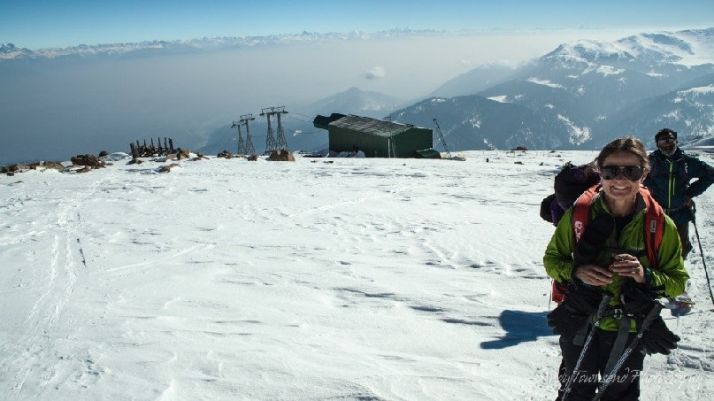 A women skier smiles above the top gondola station on Mt Apharwat in Gulmarg.