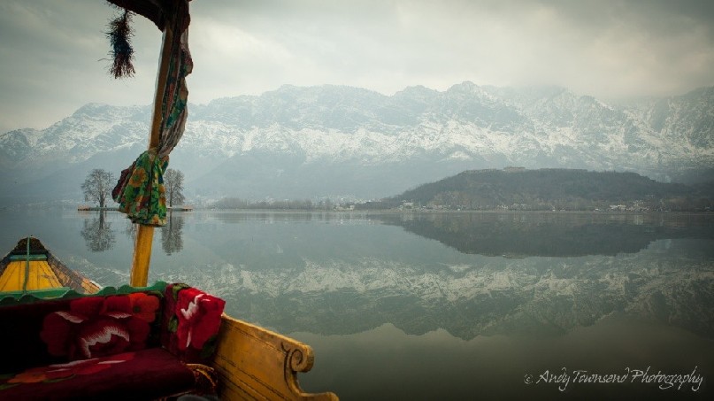 View from a Shikara out over the still waters reflecting the Zabarwan Range.