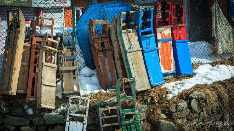 A line of colourful sleds lie against a fence in Gulmarg village.